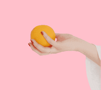 In this example, we add a solid background to a GIF animation of a hand holding an orange. To do this, we select the "Use a Single Color" option and enter the color "pink" in the background color field. (Source: Pexels.)