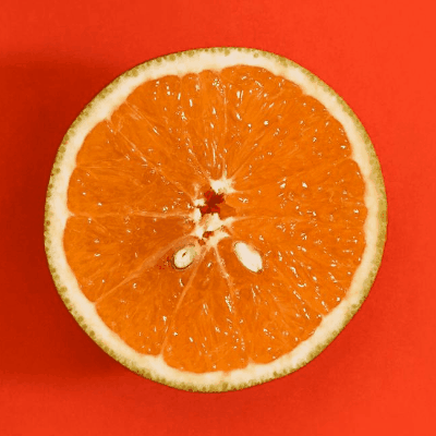 In this example, we load a static square GIF of a sliced orange on a bright reddish surface and add 600 pixels of solid orange-red area (#f7431f) to the right side only. This extra area changes the image from a centered still into a masterpiece of contemporary art. The large color block creates an asymmetric design with intentional negative space intended for overlaying text or other design elements. The GIF isn't playing as it's static and contains just one frame. (Source: Pexels.)